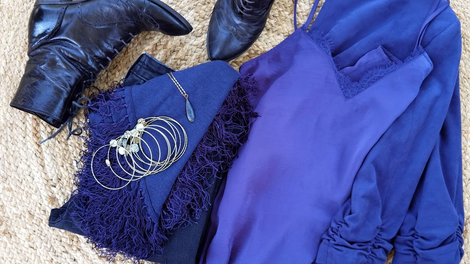 Stylish flat lay featuring black leather boots paired with a chic blue dress and stylish jewelry.