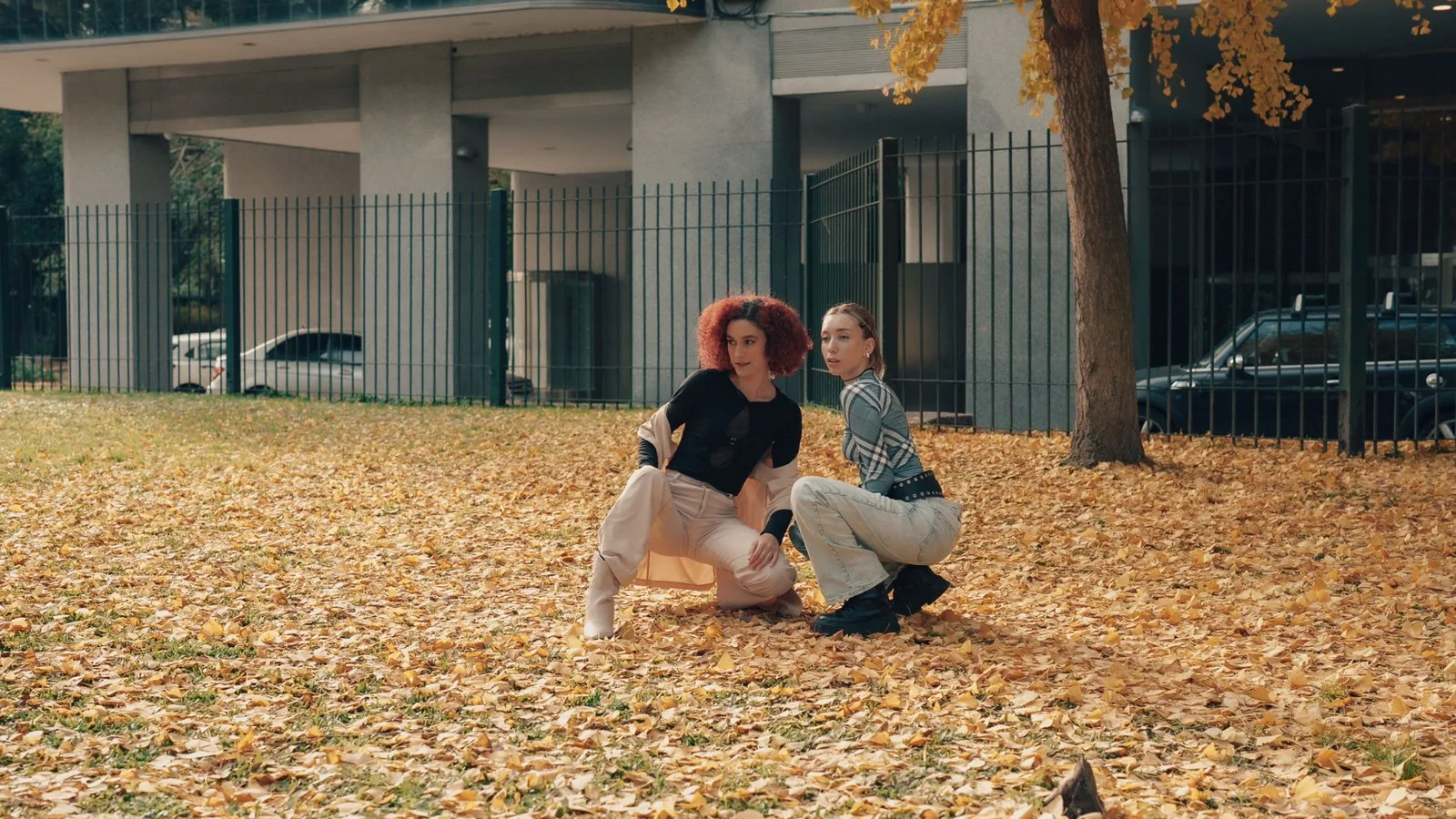 Two stylish young adults pose in a vibrant autumn scene in Buenos Aires.
