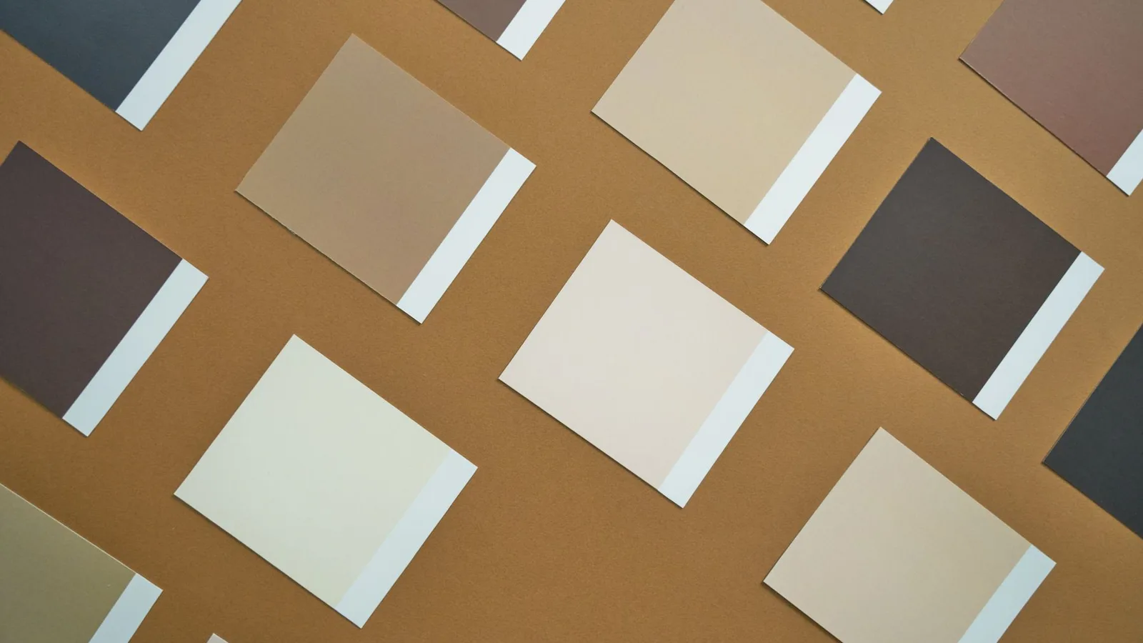 Flat lay of brown and beige paper swatches on a brown background, perfect for design inspiration.