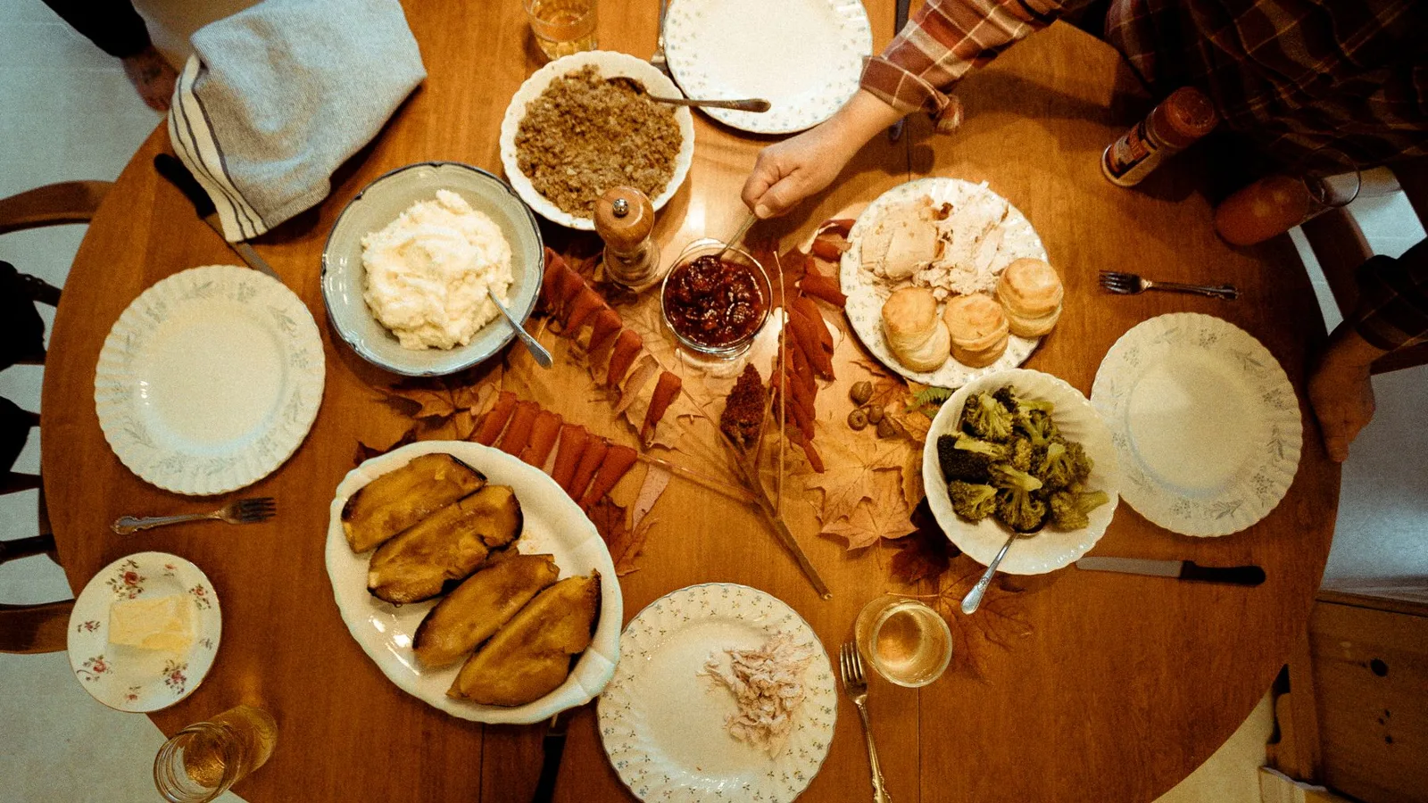 A warm autumn meal with various dishes arranged on a wooden table, perfect for a family gathering.